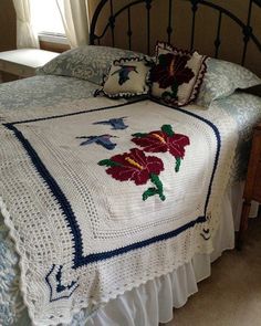 a crocheted bedspread with red flowers on it