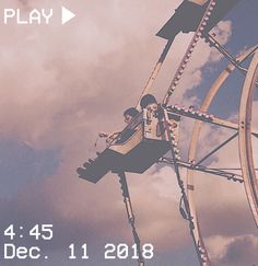 a man riding on top of a roller coaster under a cloudy blue sky with the words play below him