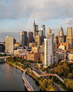 an aerial view of a city with tall buildings and a rainbow in the sky