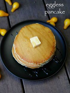 a pancake on a black plate topped with butter