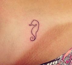 a woman's stomach with a small seahorse tattoo on her left side ribcage