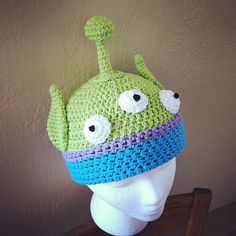 a crocheted hat with googly eyes on top of a mannequin head