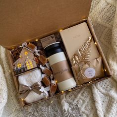 an open box with coffee, cookies and other items in it sitting on a bed