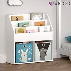 a white book shelf filled with books next to a child's bed and toys