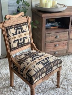 an old chair is upholstered with fabric and has been placed on the floor