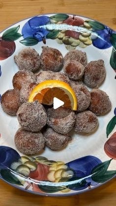 a white plate topped with donuts covered in powdered sugar and an orange slice