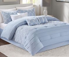 a bed with blue and white comforters in a bedroom