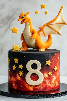 a birthday cake with a dragon on top and stars around the edges, in front of a marble background