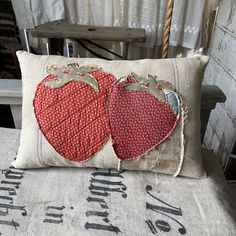 two red heart shaped pillows sitting on top of a chair