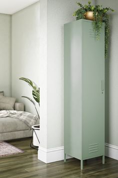 a tall pink cabinet sitting next to a living room with a plant on top of it