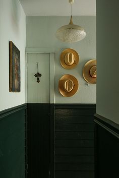 two hats are hanging on the wall in this hallway