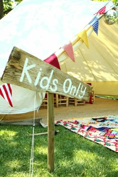 a sign that says kids only on it in front of a teepeel tent