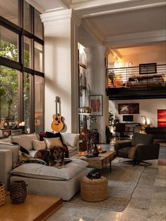 a living room filled with lots of furniture and a dog laying on top of the couch