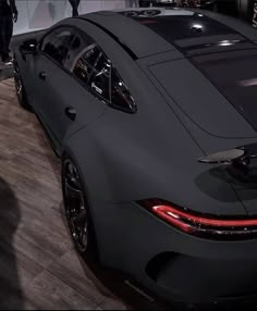 the rear end of a black sports car on display