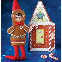 an elf is standing next to a gingerbread house