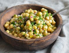 a wooden bowl filled with chickpeas and onions