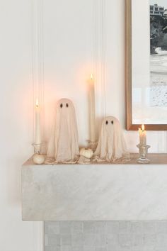 two ghost candles sitting on top of a mantle