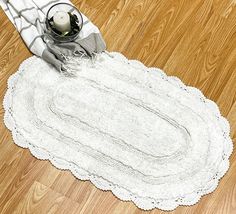 a white rug on the floor next to a candle