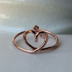 two intertwined heart shaped rings sitting on top of each other