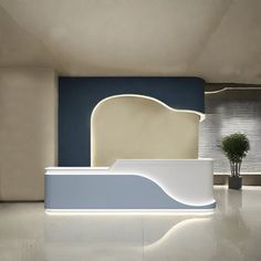 a white and blue reception desk in an office setting with plant on the side wall