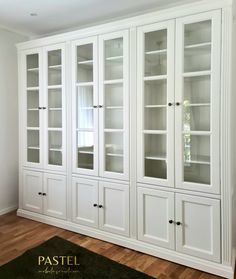 a white bookcase with glass doors in a room