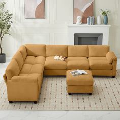 a living room with a sectional couch and footstool in front of a fireplace