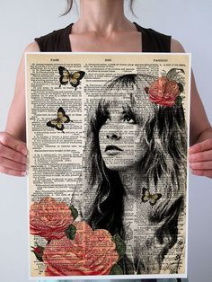 a woman holding up a poster with roses and butterflies in her hair, on top of an old book page