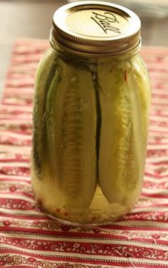 pickles in a jar sitting on a table