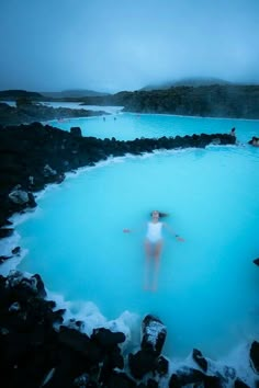 a woman standing in the middle of a blue lagoon