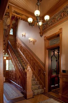 the stairs are made of wood and have intricate carvings on them, along with chandeliers