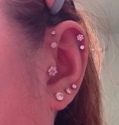 a close up of a person's ear with small flowers on the top of it