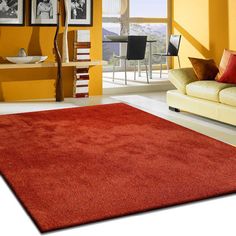 a living room with yellow walls and red carpeted area rugs on the floor