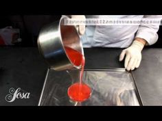 a person pouring red liquid into a pan