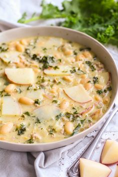 a bowl of soup with potatoes, broccoli and cheese