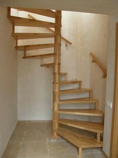 there is a wooden stair case in the room with tile flooring and white walls