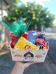 someone is holding up a gift basket with beer and snacks in it on the street