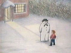 a child standing next to a snowman in front of a building with a window