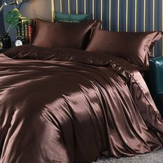 a bed with brown sheets and pillows in a room