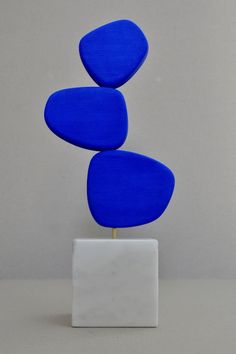 a blue sculpture sitting on top of a white block