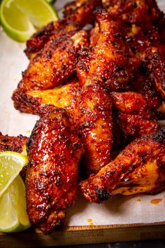 grilled chicken wings on a cutting board with lemon wedges next to them and the words smoked chicken wings made on the tray