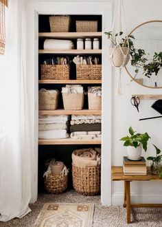 an organized closet with baskets, towels and other household items in it's shelves