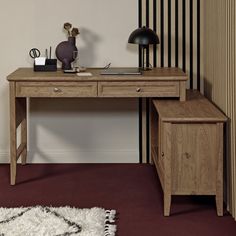 a wooden desk sitting next to a white rug