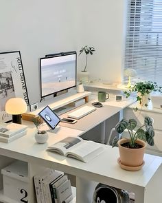 a desk with a computer monitor, laptop and books on it