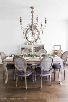 a dining room table with chairs and a chandelier