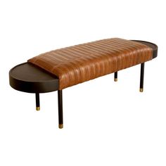 a brown leather bench sitting on top of a wooden table