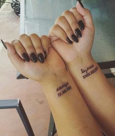 two girls with matching tattoos holding hands together, both have their fingers crossed and one has the words grandma written on it