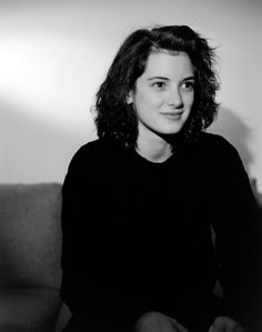 a black and white photo of a woman sitting on a couch