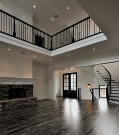 an empty living room with wood floors and stairs