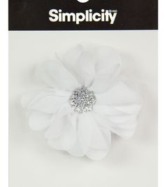 a white flower with some crystal stones on it's center and the words simplicity