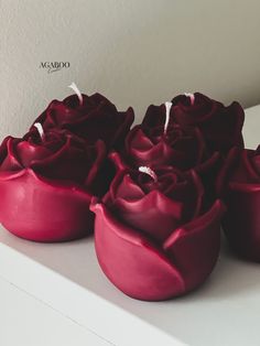 three red roses sitting on top of a white table